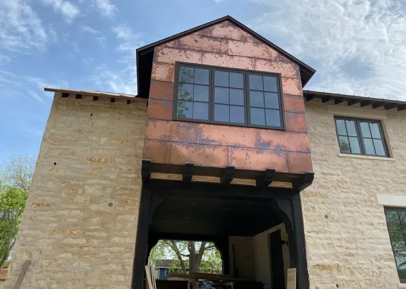 Copper metal panel facade on a stone building for Roof Repair in Hugo